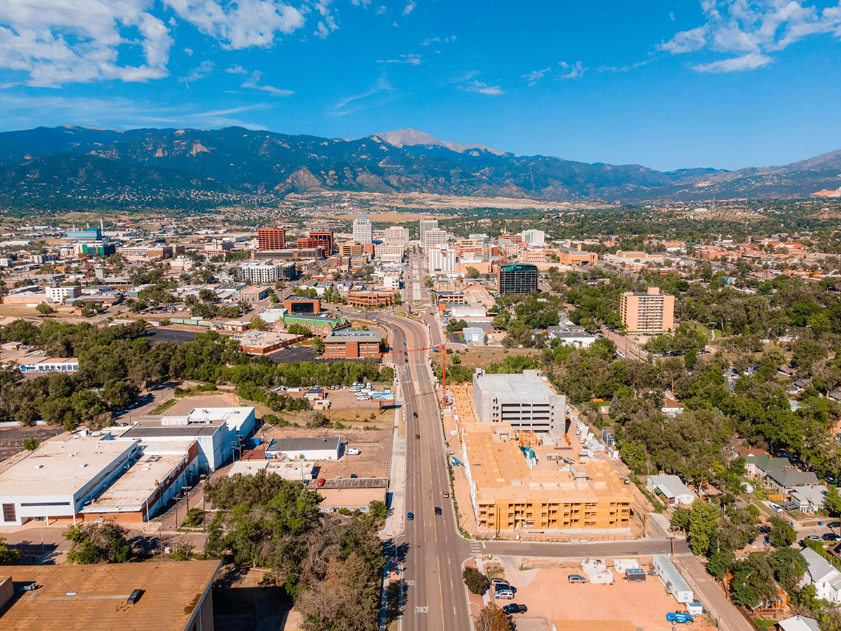 Daytime, aerial view of a main road in Colorado Springs with mountains in the background